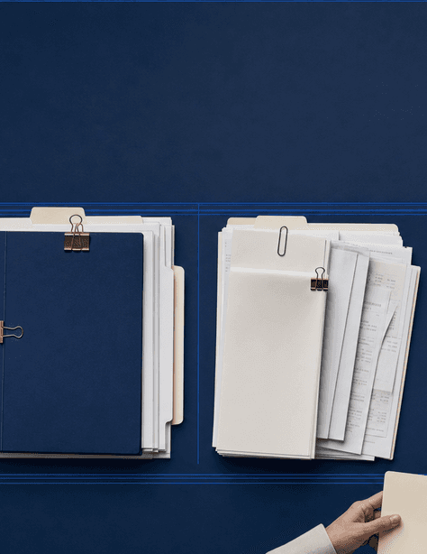 Four document stacks on a dark register desk: an individual return packet, a business ledger, professional receipts, and an estate folder